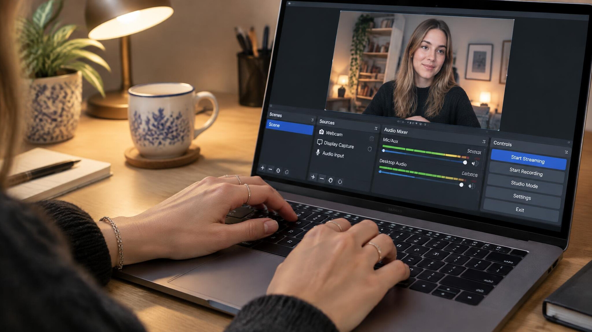 Hands typing on a laptop running streaming software